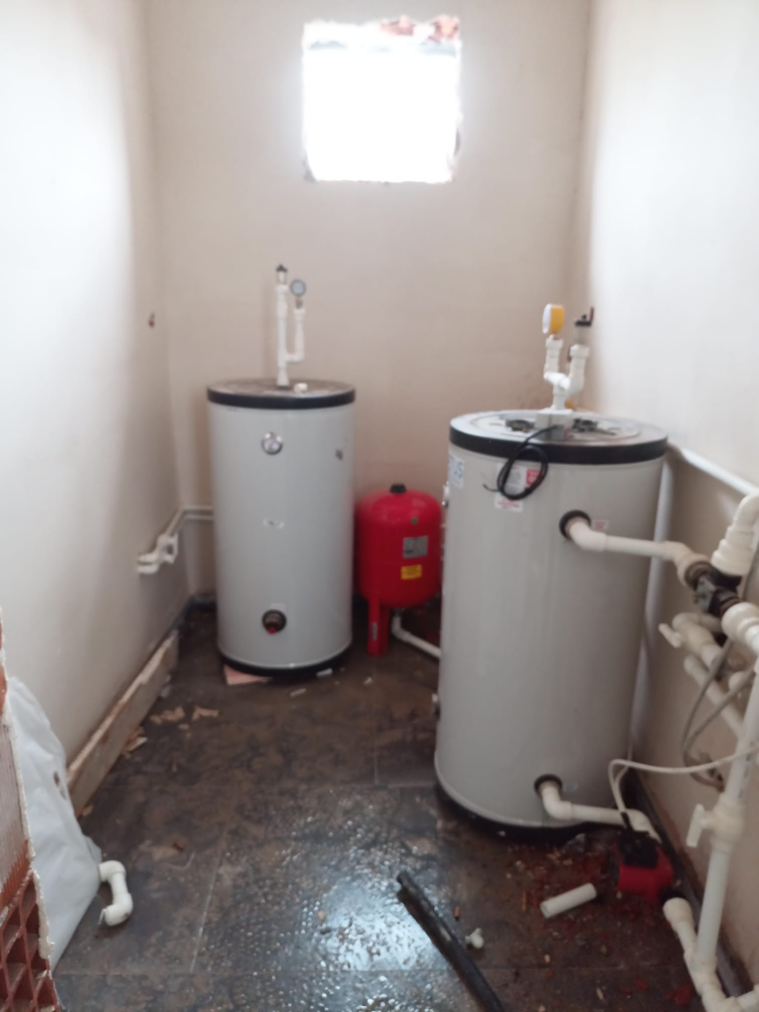 Teknik odada iki dikey tank, genleşme tankı ve PPRC tesisat bağlantıları