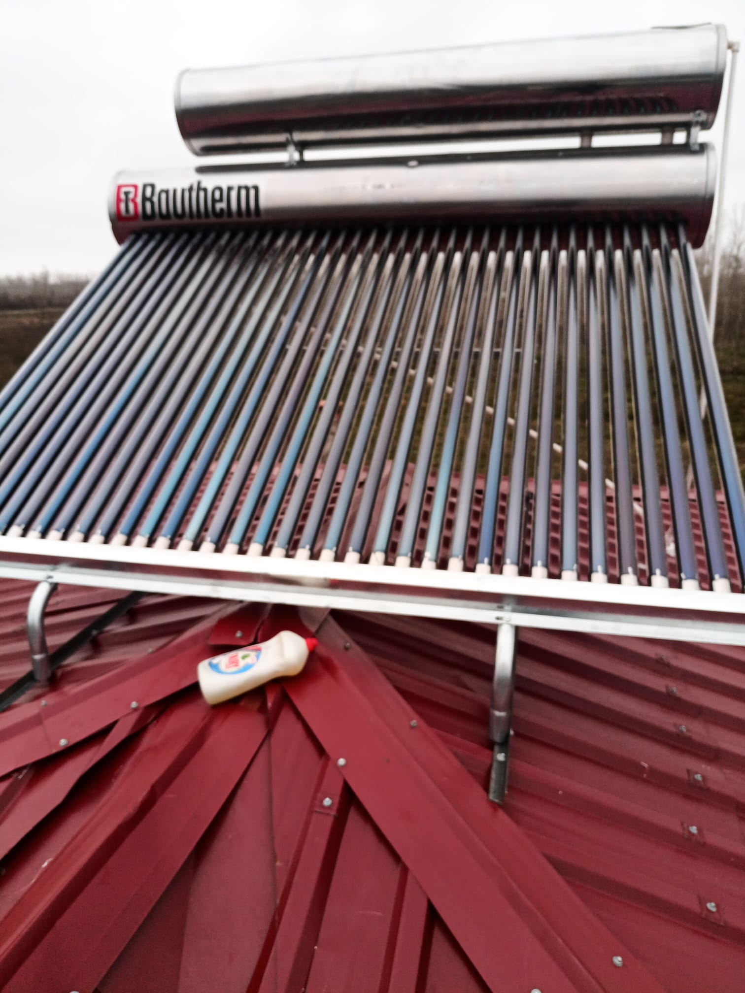 Kırmızı metal çatıya monte edilmiş çift depolu vakum tüplü güneş enerjisi sistemi