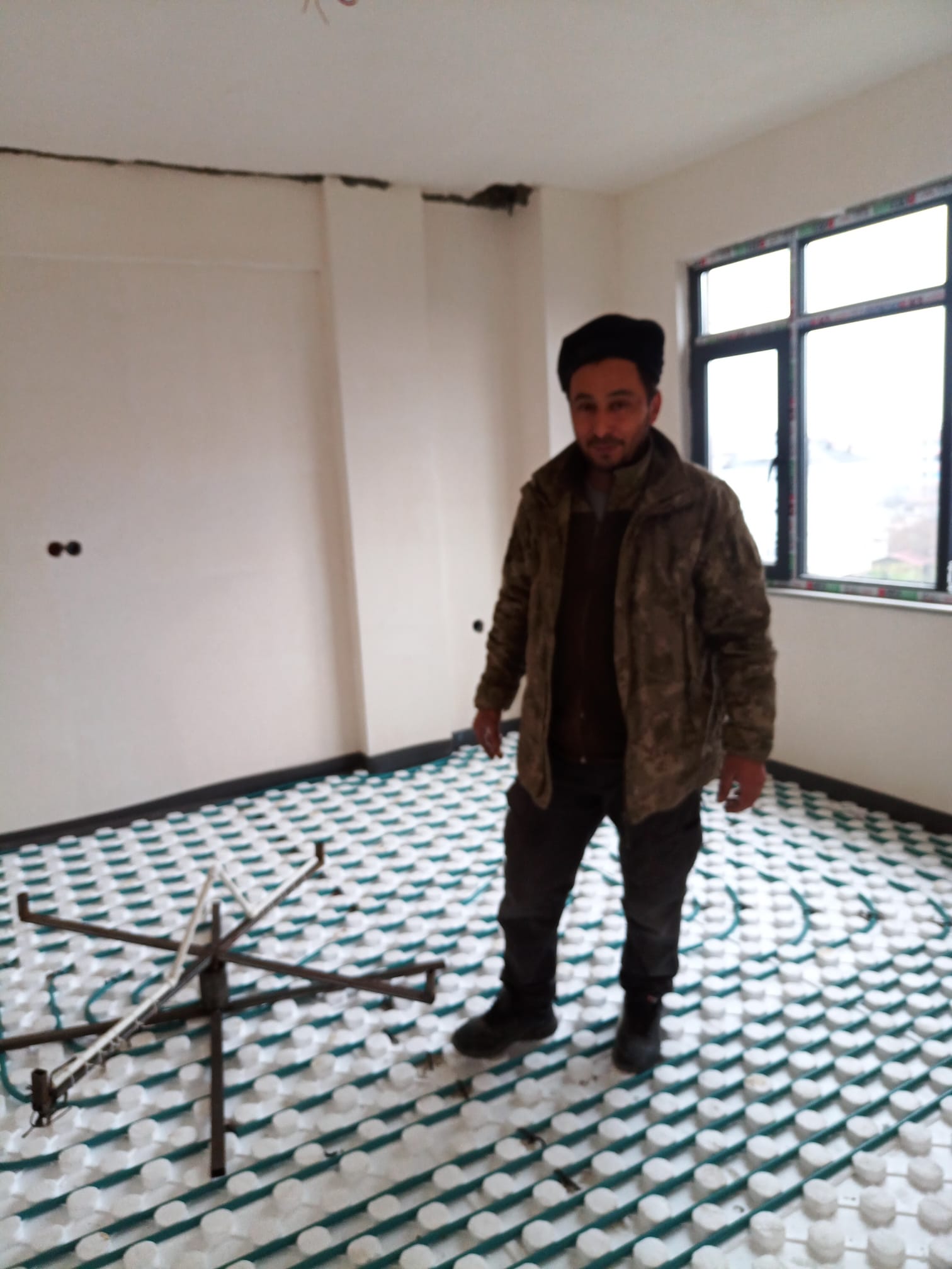 Yalıtım paneli üzerinde yeşil borularla hazırlanan sulu yerden ısıtma montajı